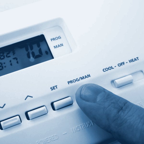Hand adjusting a programmable thermostat